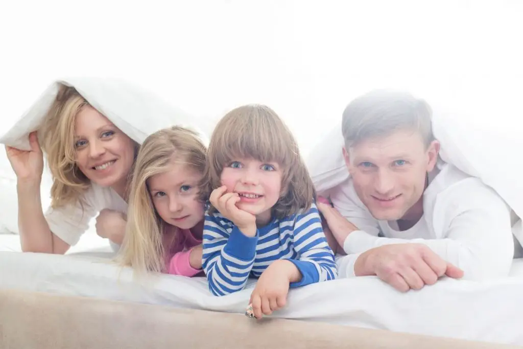 Family in a bed under a blanket