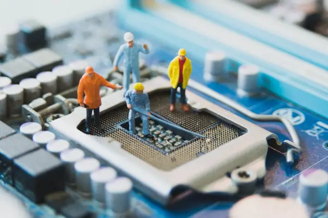 Toy men fixing a microprocessor