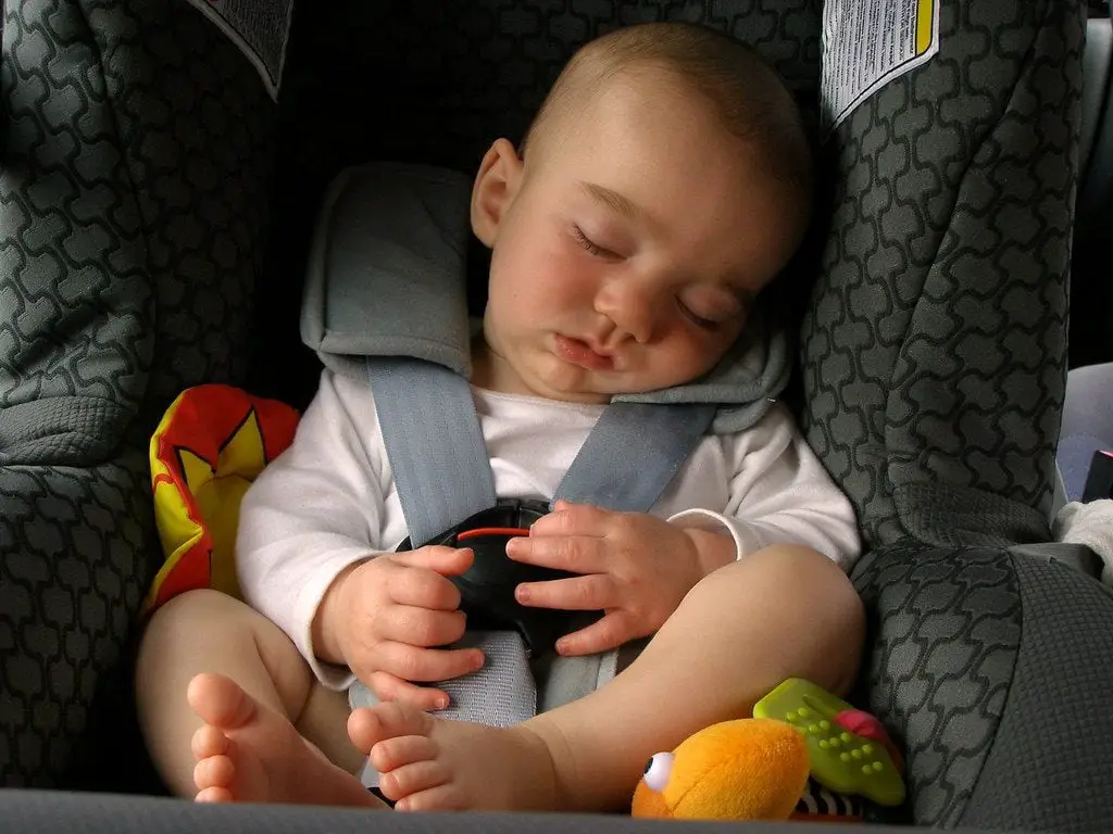 A child sleeping in a car seat for toddlers