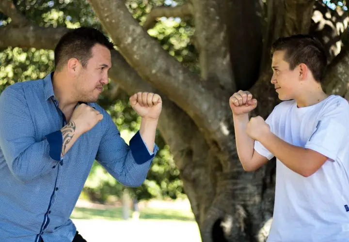 Father play boxing with his teen son