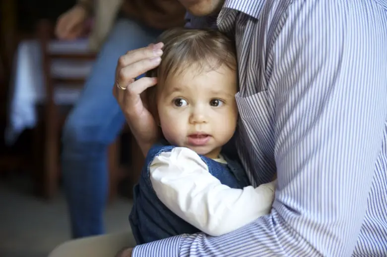 A child held by his father