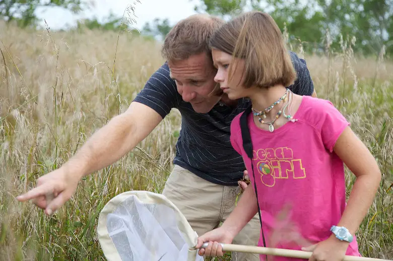 A father catching bugs with his daughter