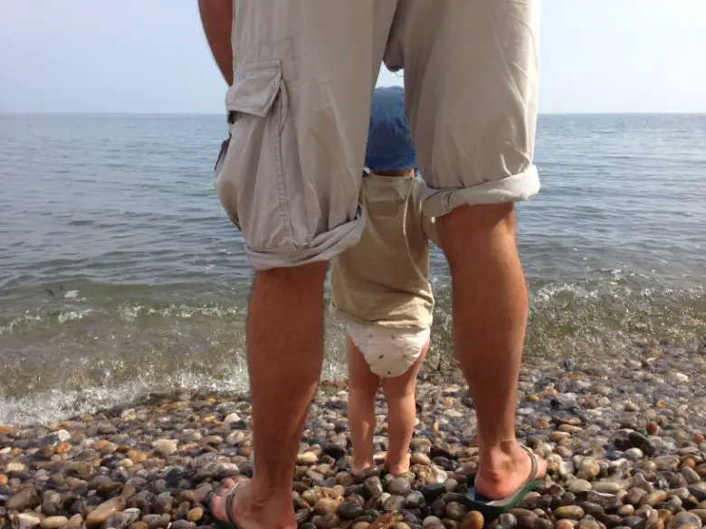 Father holding son at the water's edge