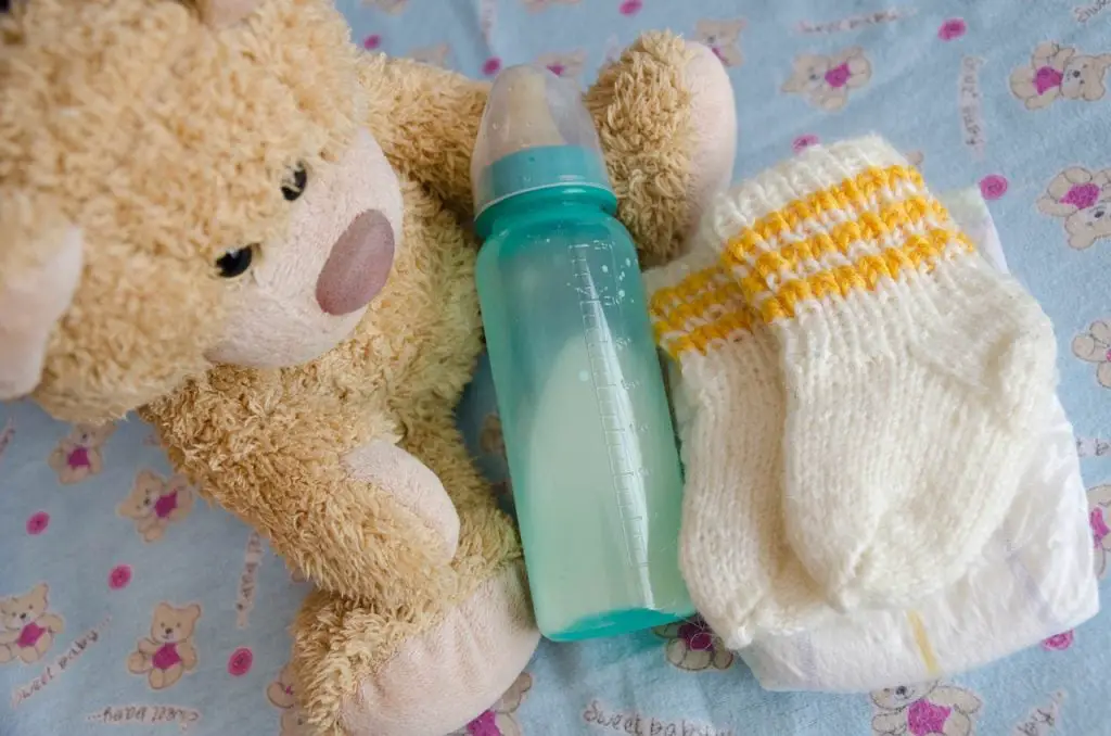 Bottle, baby booties and bear
