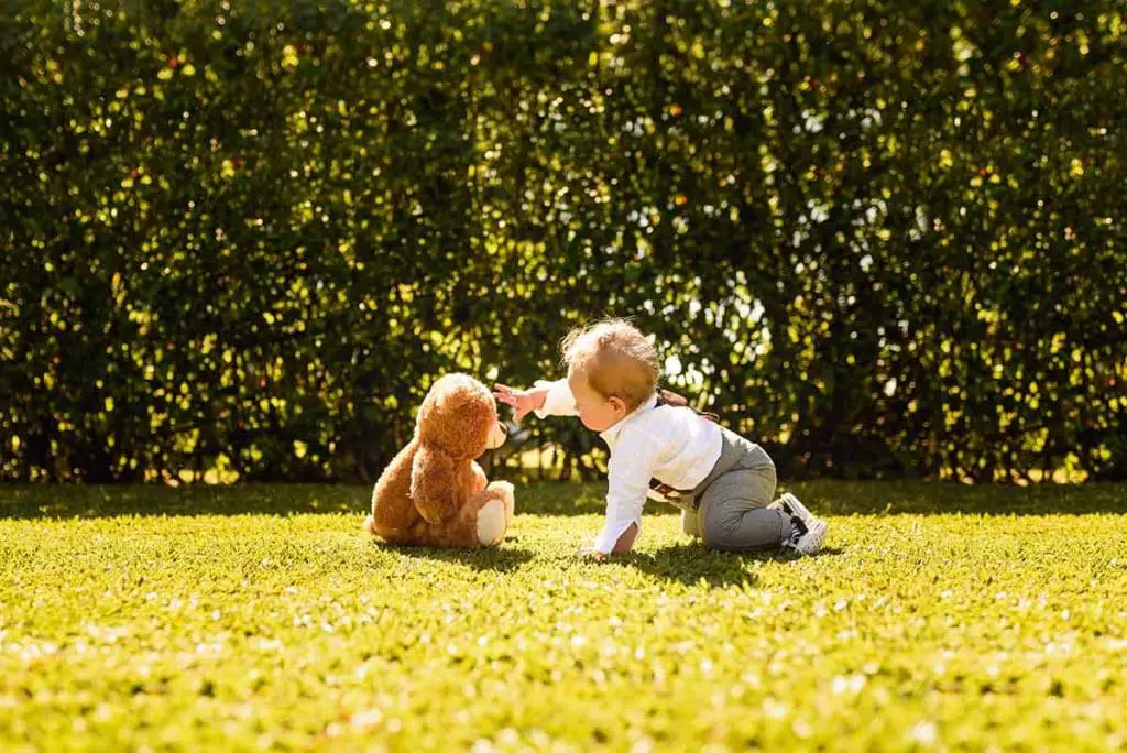 Baby playing with a teddy bear