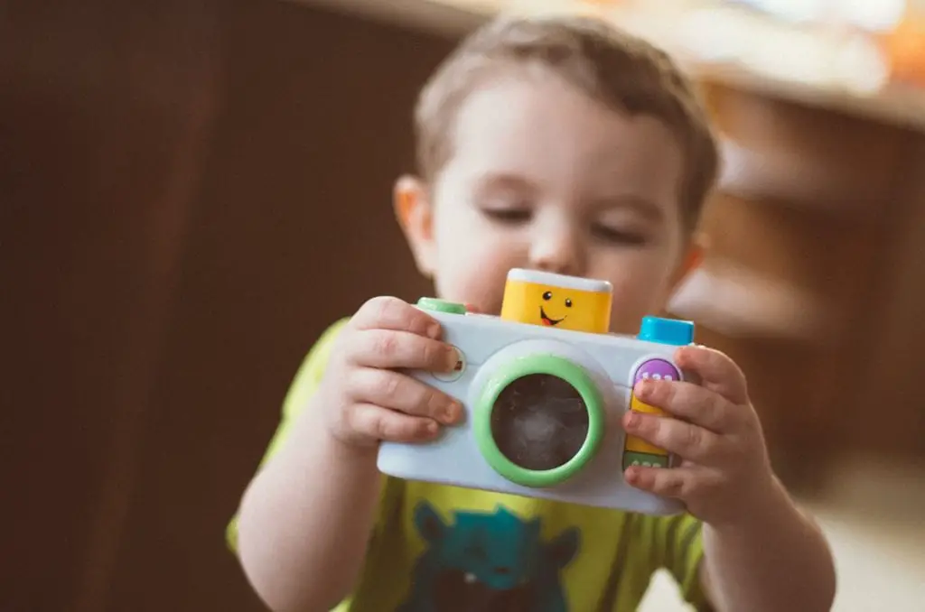 Baby holding a camera toy