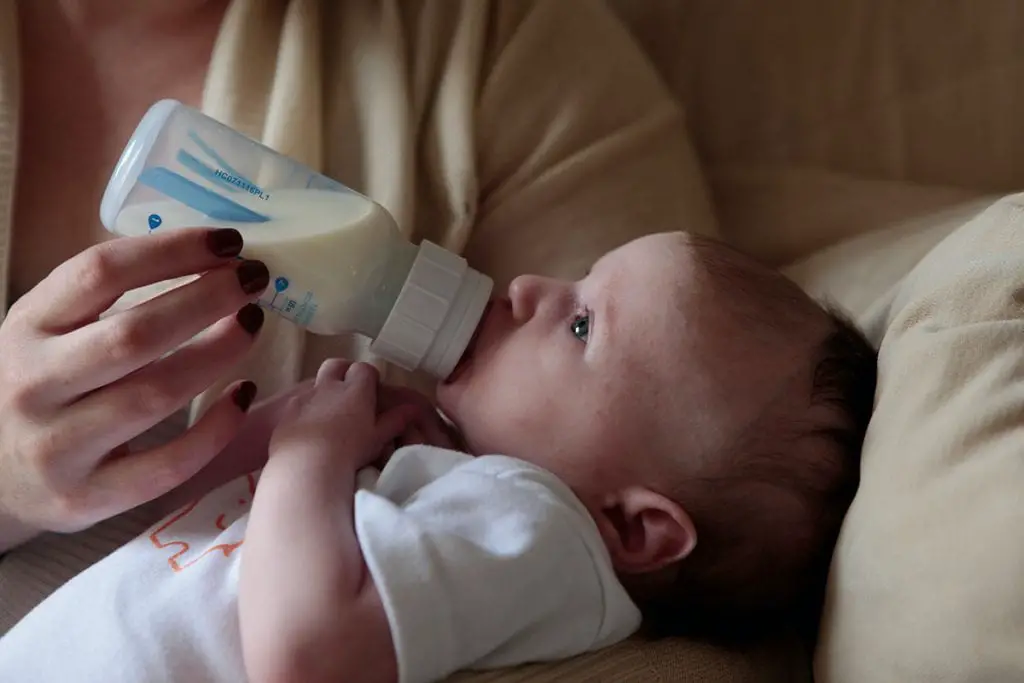 baby's drinking milk in a bottle